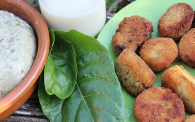 plato de croquetas junto a una botella de leche de avena y hojas de acelga
